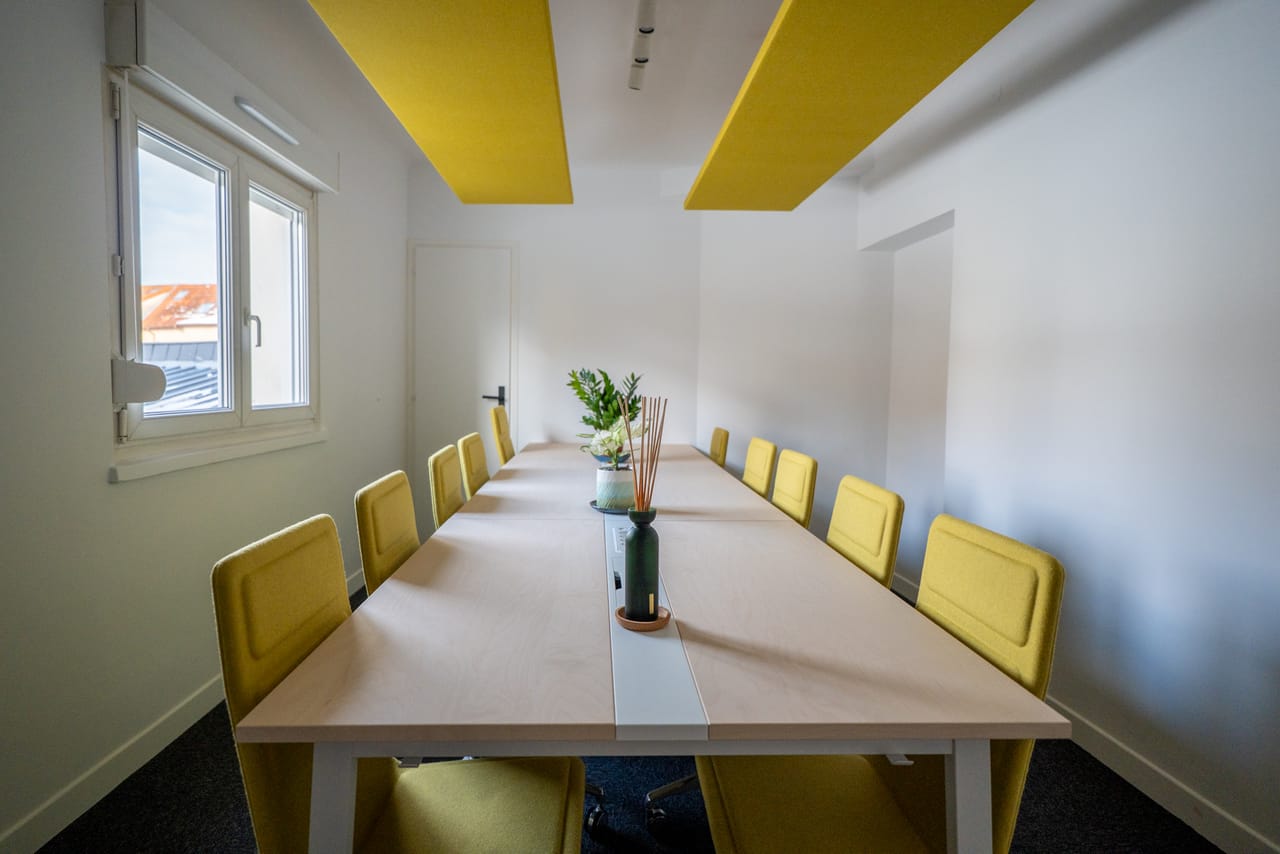 Table de conférence de la salle de réunion avec dix chaises jaunes